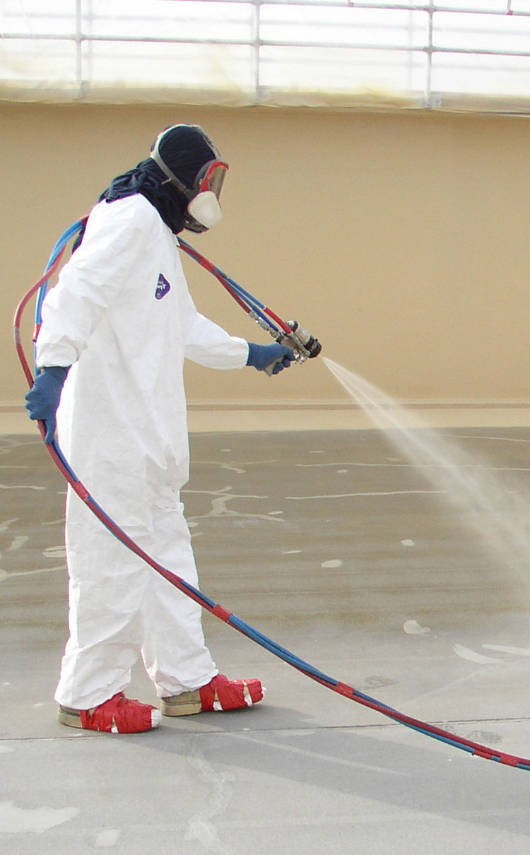 Man in protective gear spraying primer